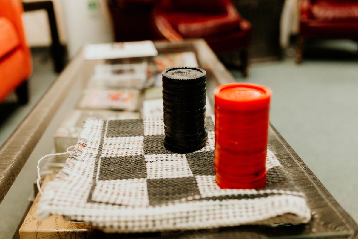 A checkerboard laid out with stacks of black and red pieces, ready for a game.