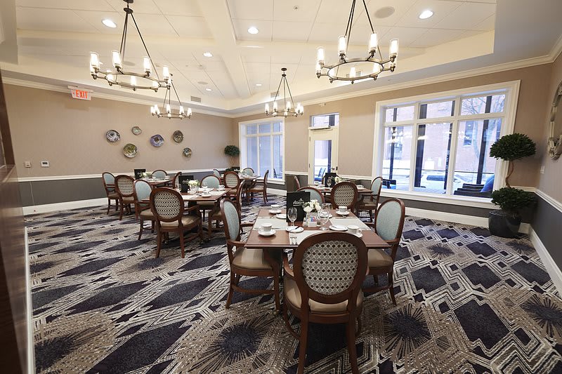 An elegant dining area with chandeliers and neatly set tables.