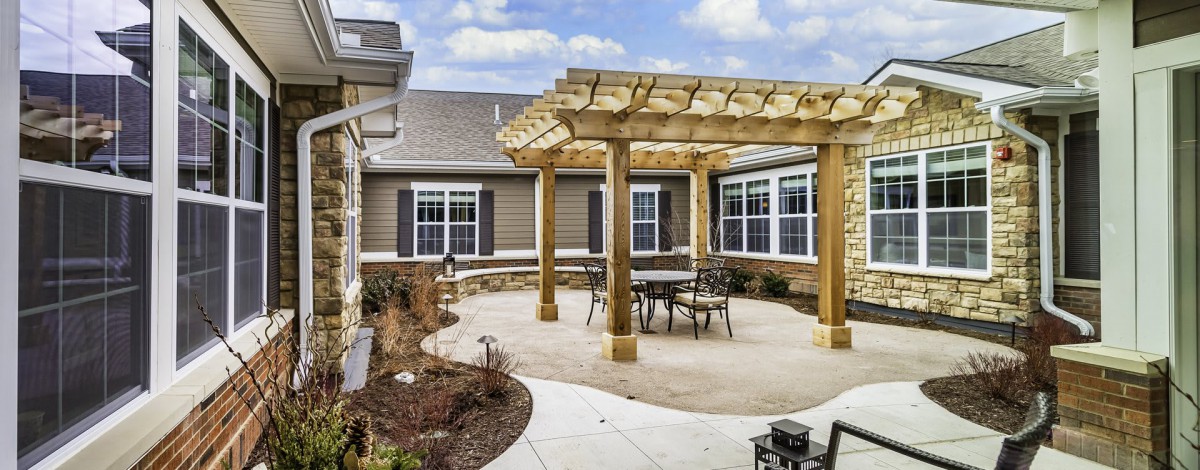 A cozy outdoor patio with a wooden pergola and seating area.