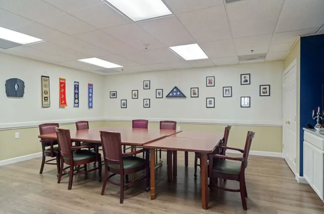 A well-lit conference room with tables and chairs, adorned with photographs and wall decorations.