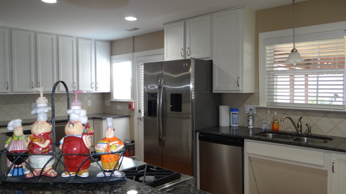 A modern kitchen with stainless steel appliances and white cabinets.