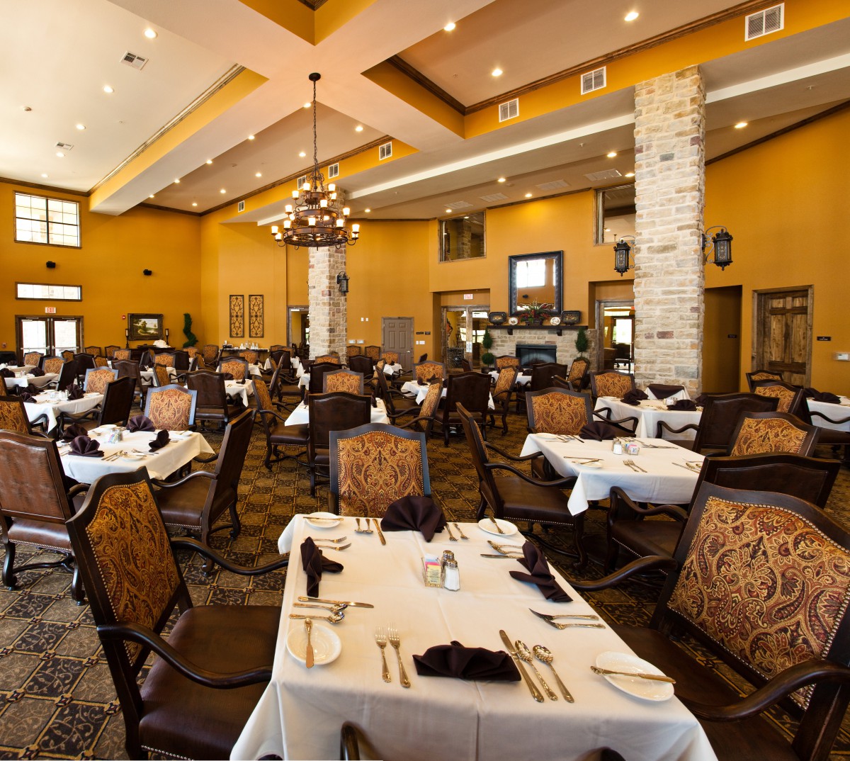 Elegant restaurant dining room with well-arranged tables and chairs, featuring classic decor and a chandelier.