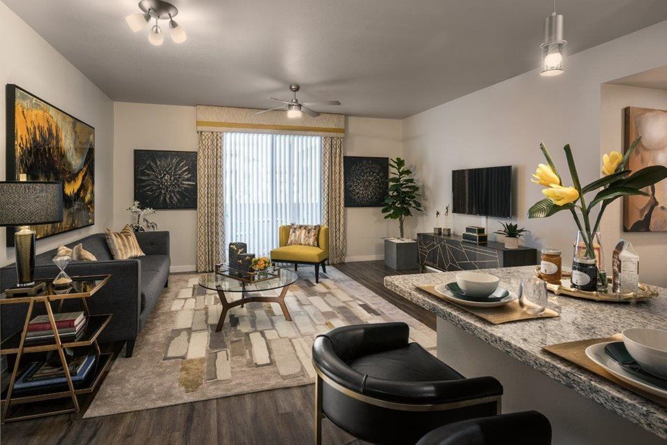 A modern living room with stylish furniture and decor, featuring a cozy seating and dining area.