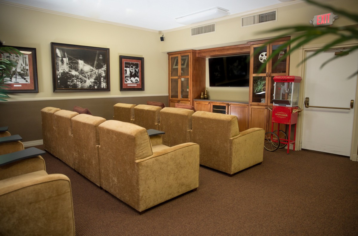 A cozy home theater setup with comfortable seating, a large screen, and a popcorn machine.