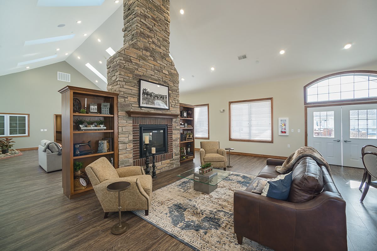 A spacious living room featuring a central stone fireplace, cozy seating, and elegant decor.