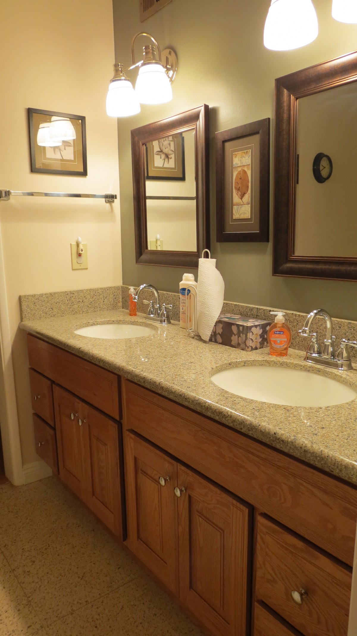 A neatly organized bathroom with a double sink and mirrors above.