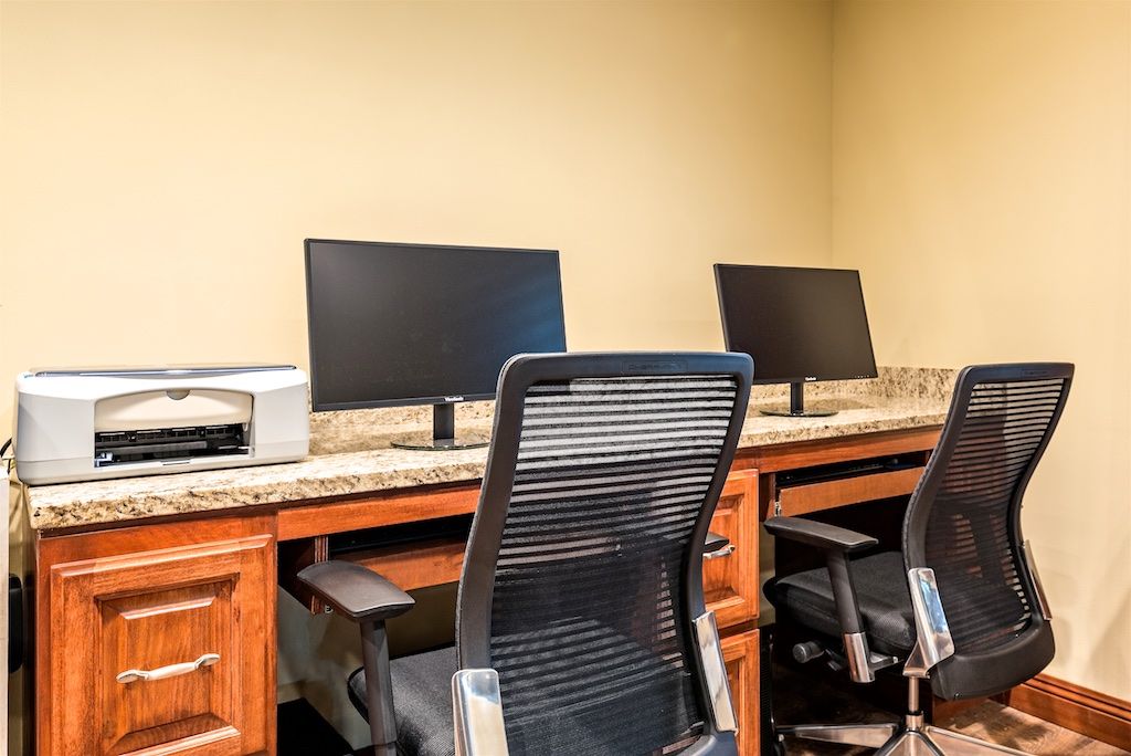 A modern office workspace with two computers and ergonomic chairs.