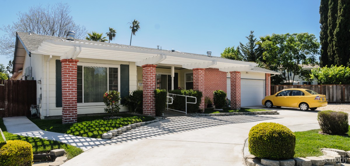 A suburban single-story house with a driveway and landscaped front yard.