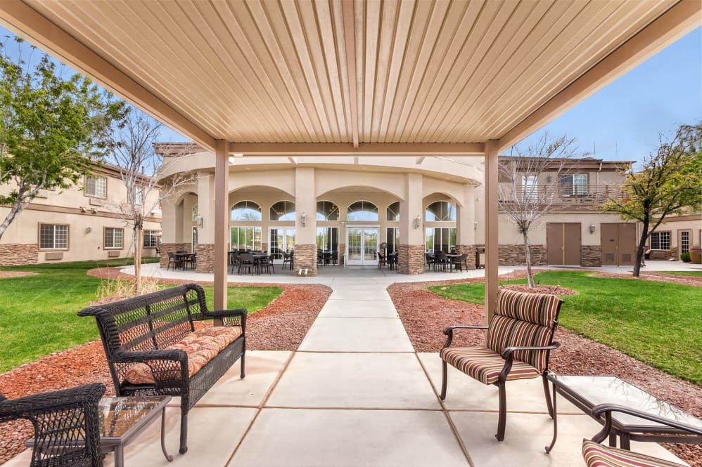 A serene outdoor seating area with benches and a pathway leading to a building's entrance.