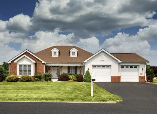 A charming suburban home with a well-maintained lawn and a cloudy sky backdrop.