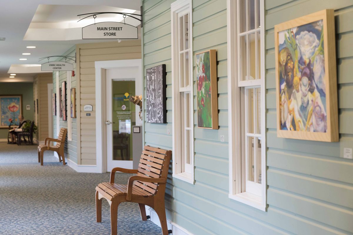 A cozy hallway featuring wooden benches and artwork on the walls.