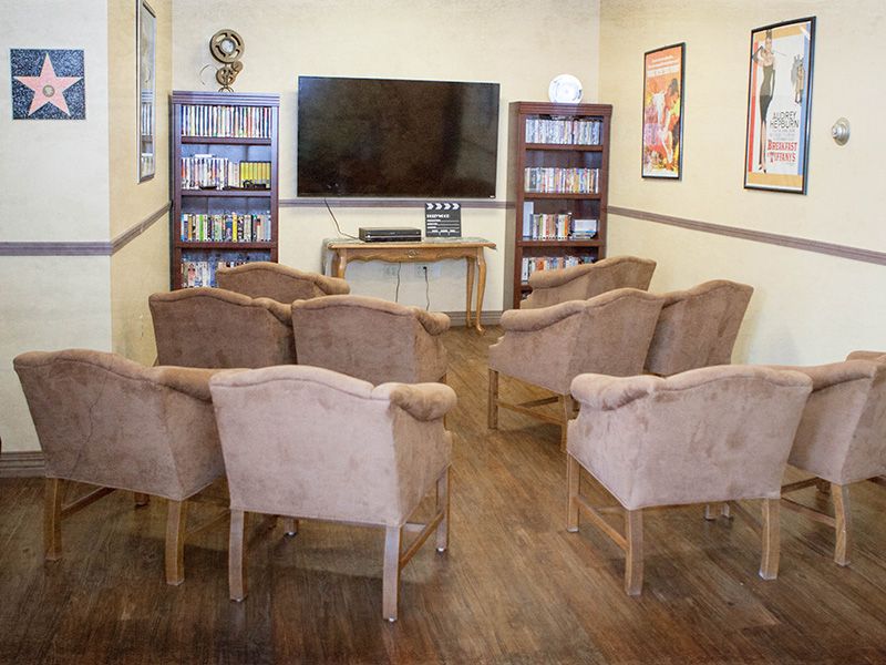 A cozy entertainment area with a television, bookshelves, and comfortable seating.