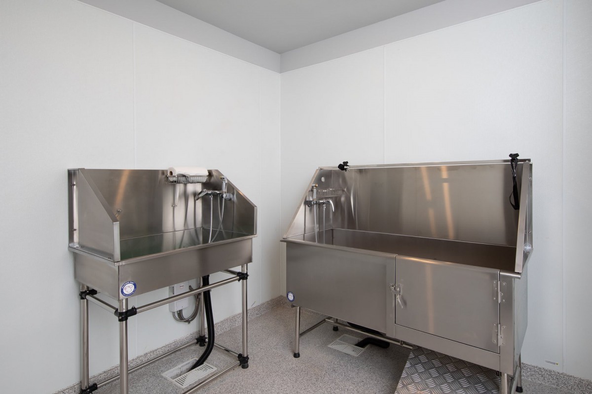 Image of an industrial cleaning area with stainless steel sinks and equipment.