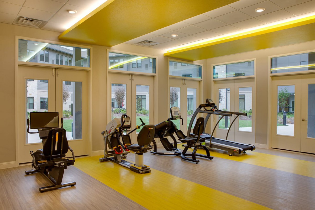 A modern gym with various exercise equipment including treadmills and bikes.