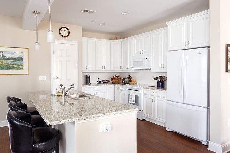 A modern kitchen with white cabinets and an island.