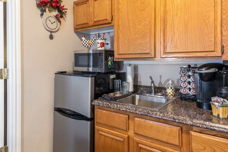 Compact kitchen area with a mini fridge, microwave, and coffee maker on the countertop.