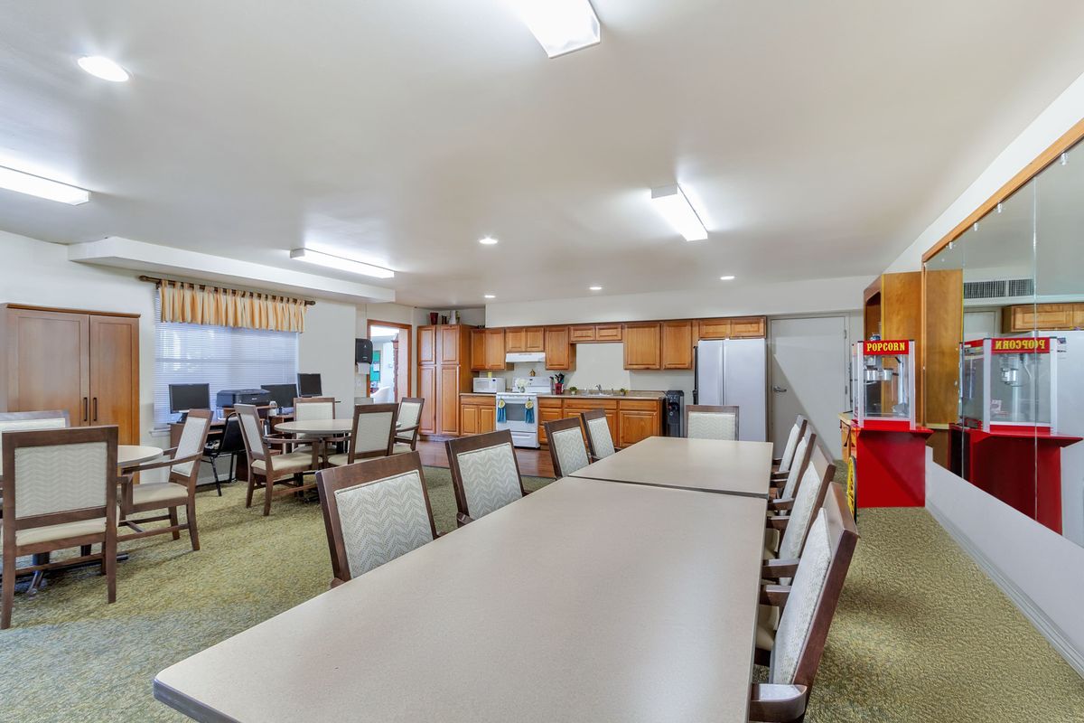 A spacious meeting area with a kitchenette and seating arrangement.