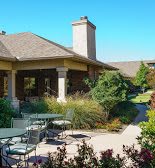 A tranquil outdoor patio surrounded by lush greenery and elegant architecture.