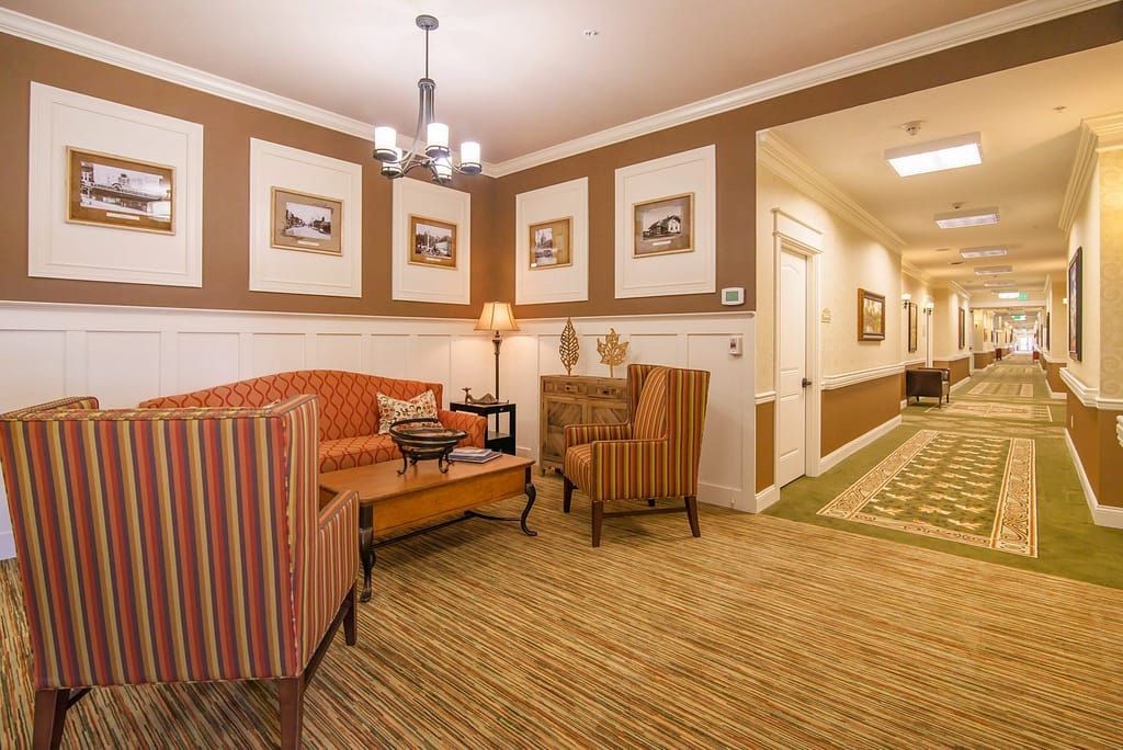 A warm and inviting lobby area featuring comfortable seating, modern lighting, and framed artwork on the walls.