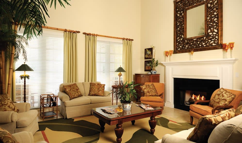 A cozy living room with a sofa, armchair, and a fireplace.
