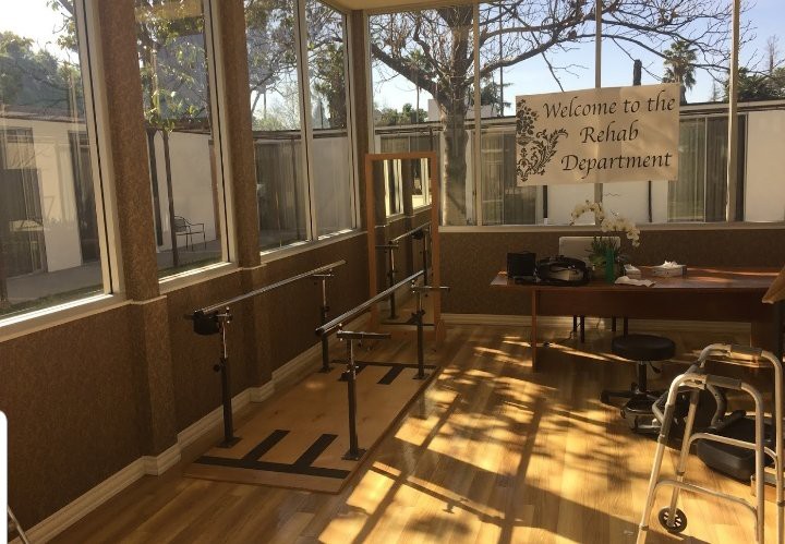 A sunlit rehabilitation room equipped with parallel bars for physical therapy.