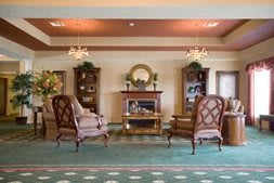 A classic living room interior with elegant furniture, a fireplace, and chandeliers.