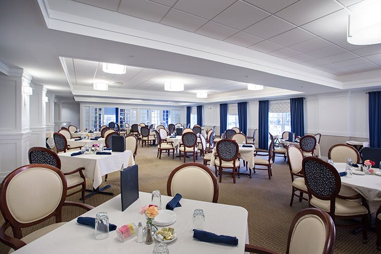 An elegant dining room with neatly arranged tables and chairs, set for guests.