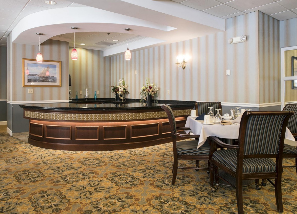 An elegant dining area with tables set for guests, featuring classic decor and floral arrangements.