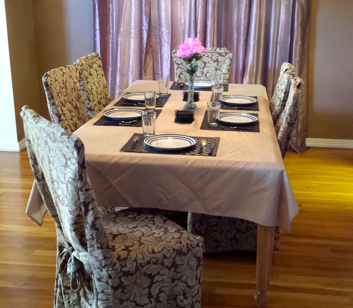 A well-set dining table with elegant decor and a flower centerpiece.