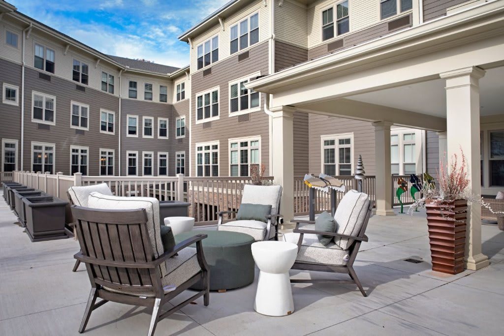 A modern apartment complex with a spacious outdoor patio featuring comfortable seating arrangements.