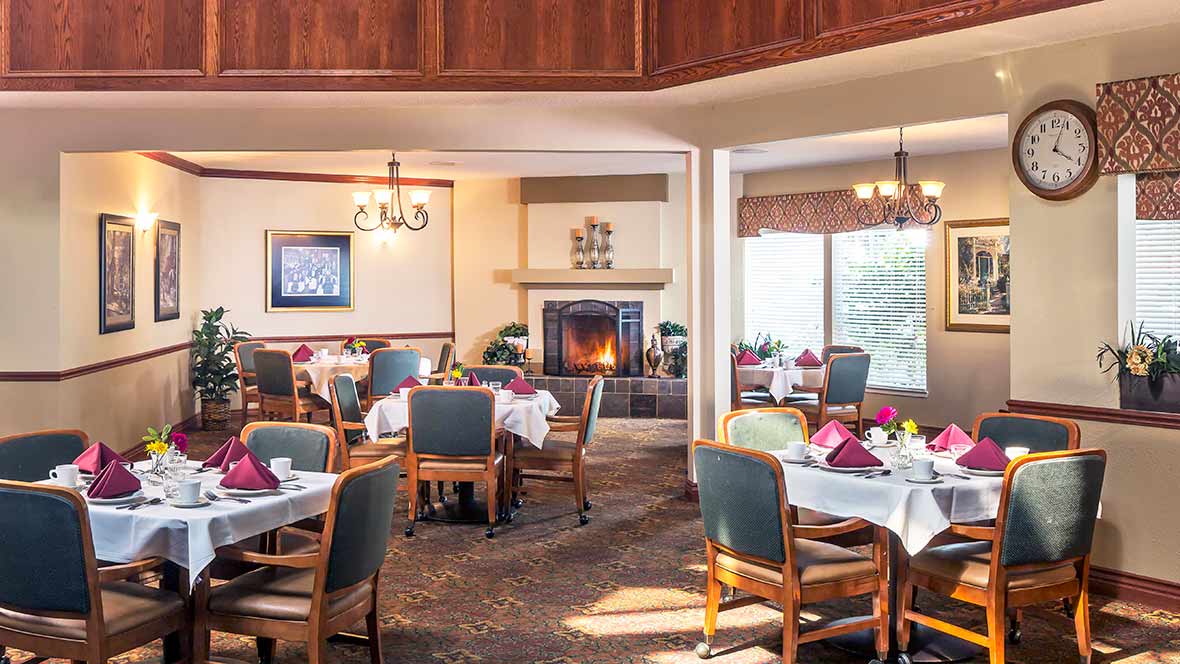 A cozy restaurant dining area featuring a warm fireplace and neatly arranged tables and chairs.