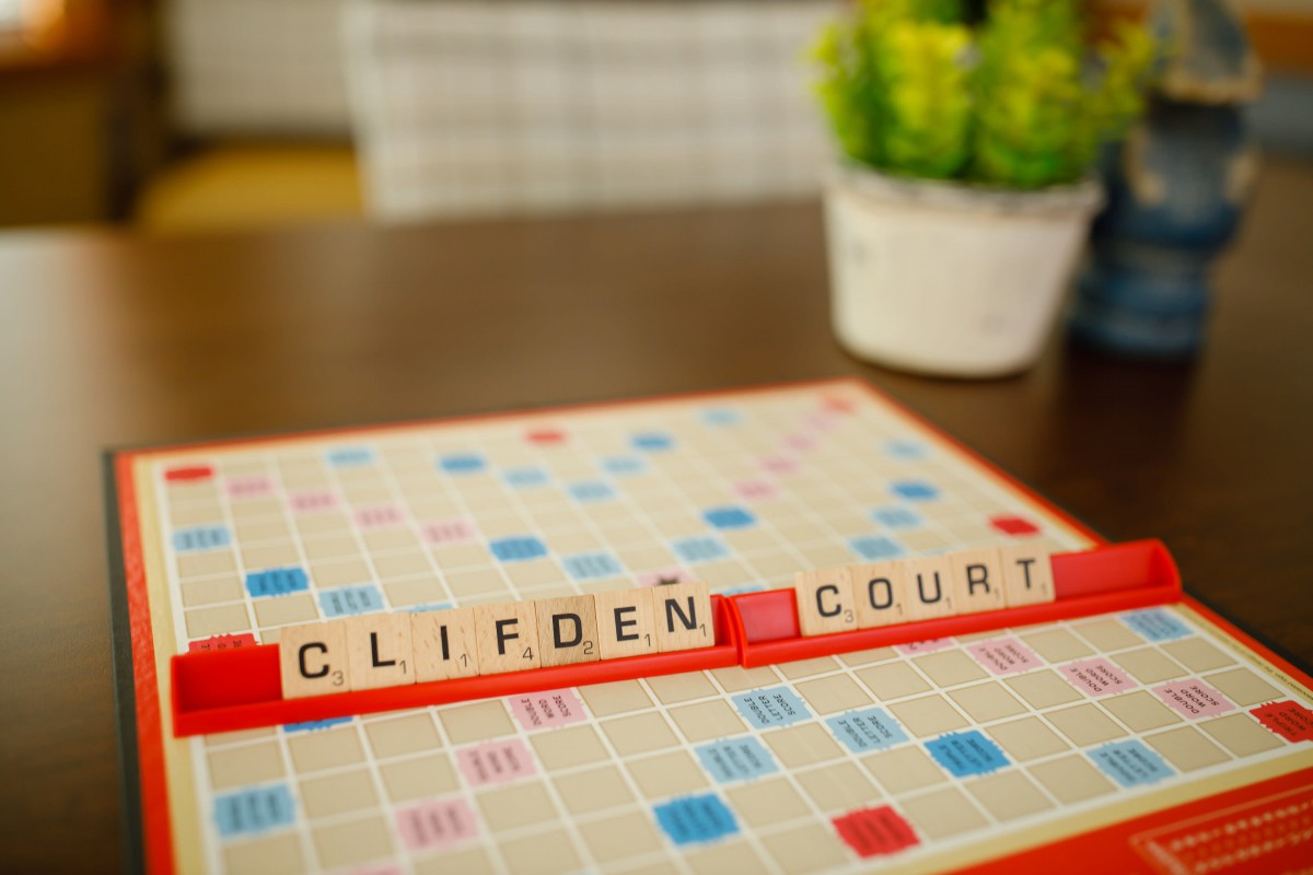 Scrabble game board with the words 'CLIFDEN COURT' arranged on it.