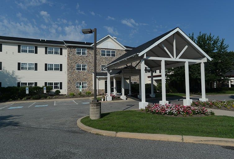 A residential building with a covered entrance and landscaped surroundings.