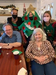 A festive family gathering with Christmas-themed costumes and cheerful smiles.