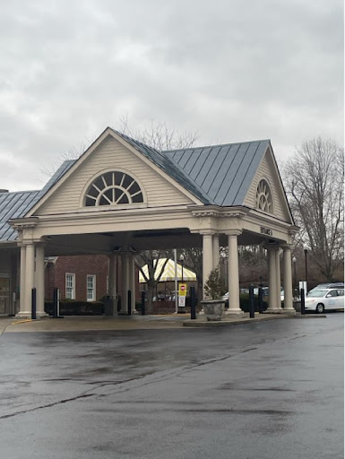 A welcoming entrance of a commercial building under a cloudy sky.