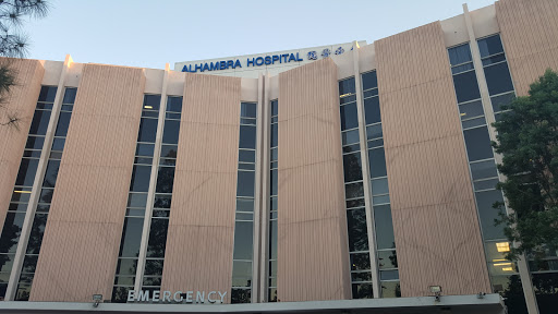 Exterior view of Alhambra Hospital, showcasing its modern design and large windows.