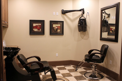 A cozy barber shop featuring black chairs and vintage styling tools, with framed artwork on the walls.