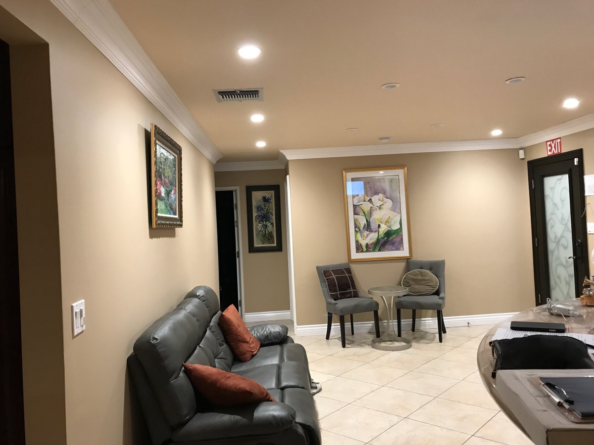 A well-lit living room with artwork, seating area, and modern decor.