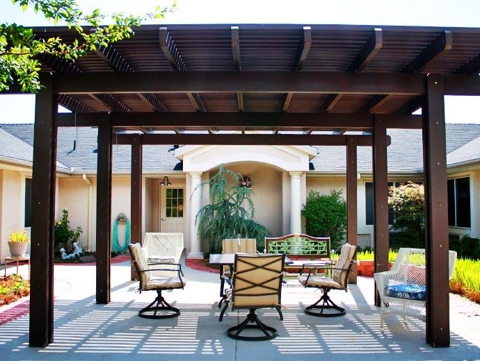 A beautifully designed patio with a wooden pergola and outdoor furniture set.
