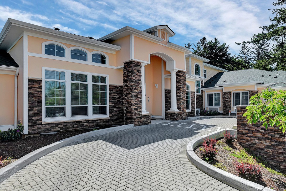 A modern, elegant house with a landscaped driveway and stone accents.
