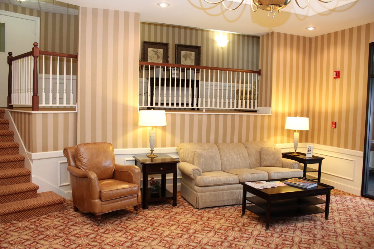 A cozy living room with a sofa, armchair, and stylish decor.
