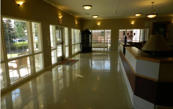 A well-lit hallway with large windows and shiny floors.