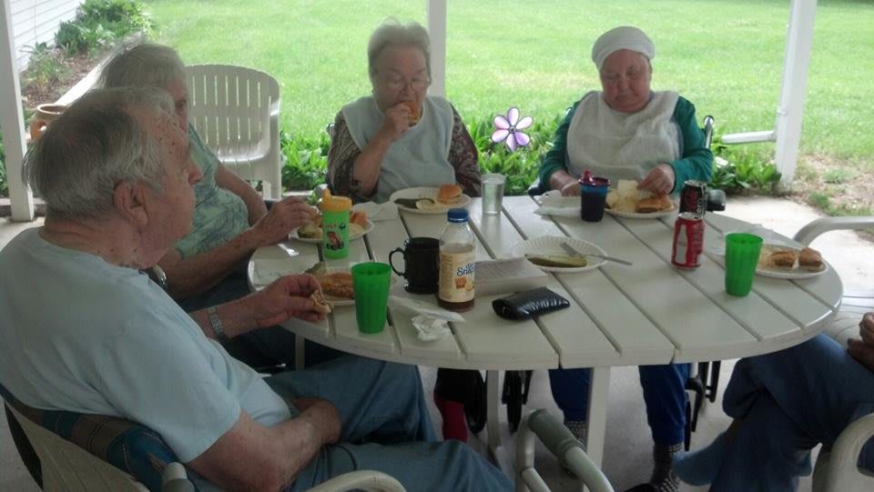 A group of people enjoying a meal together at an outdoor table.
