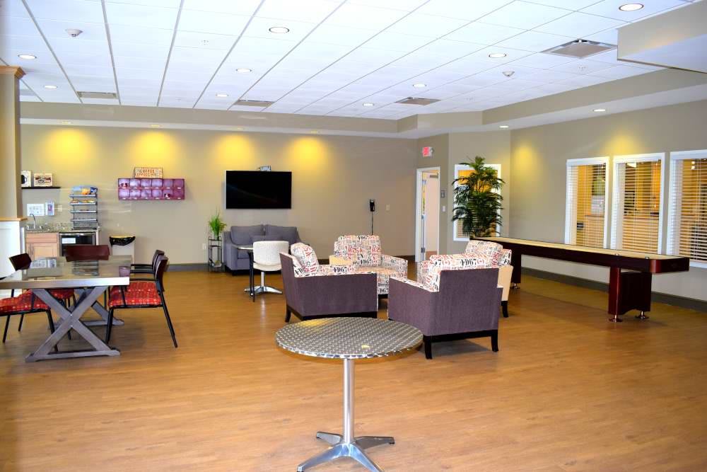 A spacious lounge area with comfortable seating and a television.