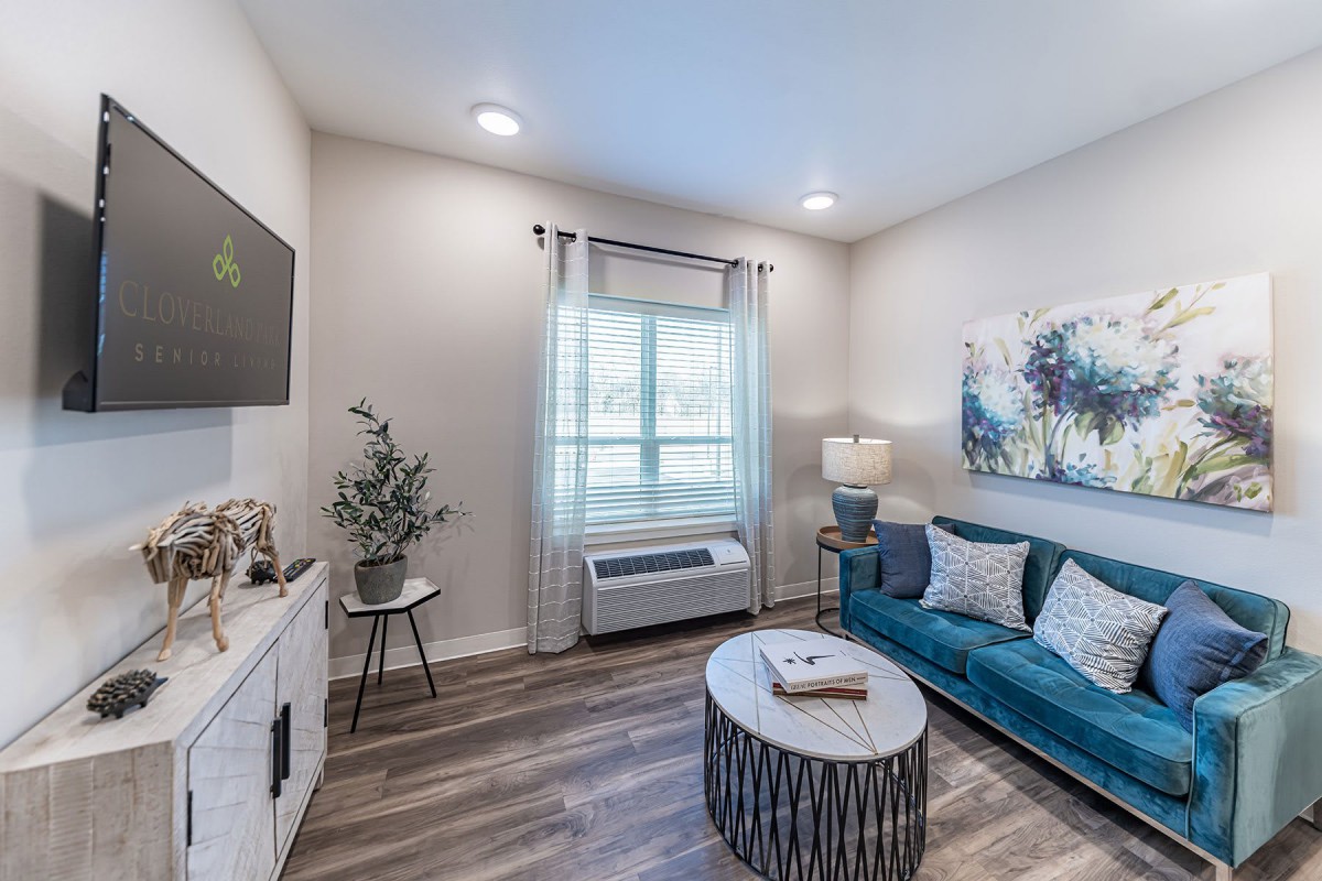 A modern living room with a blue sofa, abstract artwork, and a stylish coffee table.