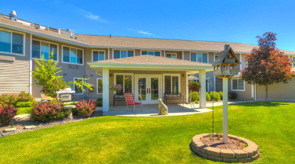 A beautiful suburban house with a well-maintained backyard and patio.