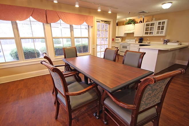 A cozy dining area with a wooden table and chairs, adjacent to a kitchen.
