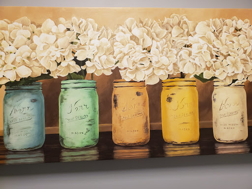 A charming arrangement of colorful jars filled with elegant flowers, perfect for brightening any space.