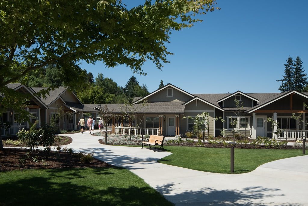 A residential building surrounded by a landscaped garden and pathway.