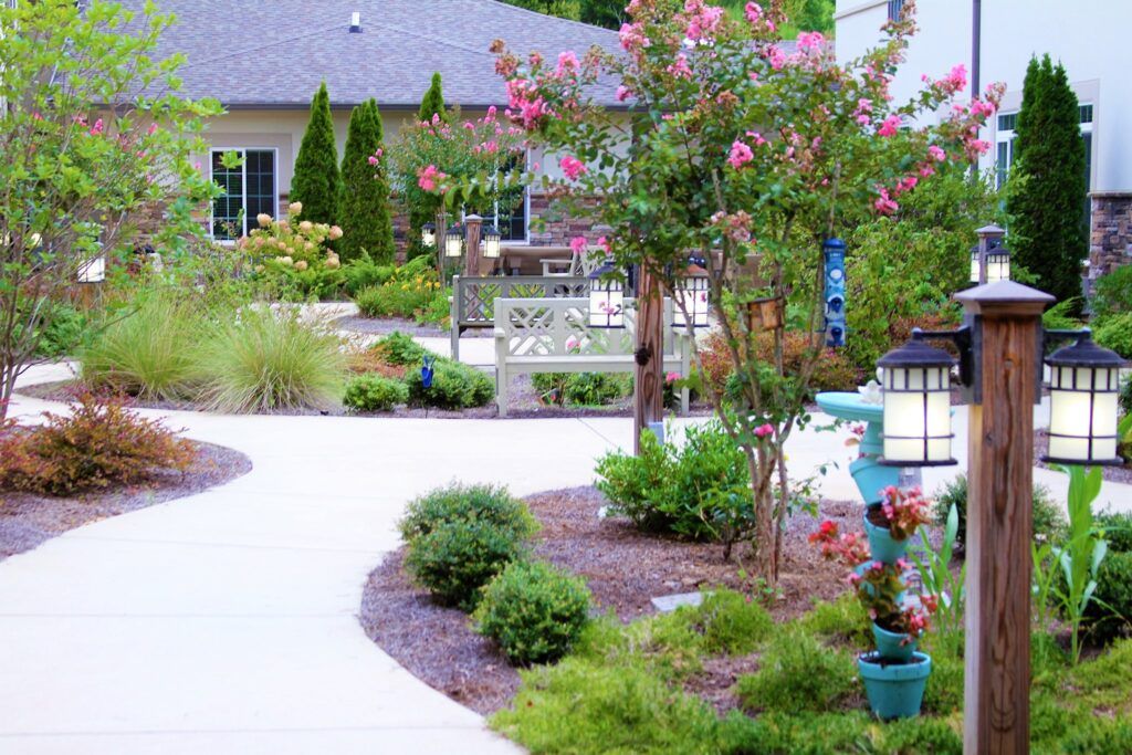 A beautifully landscaped garden with a winding pathway surrounded by flowers and shrubs.